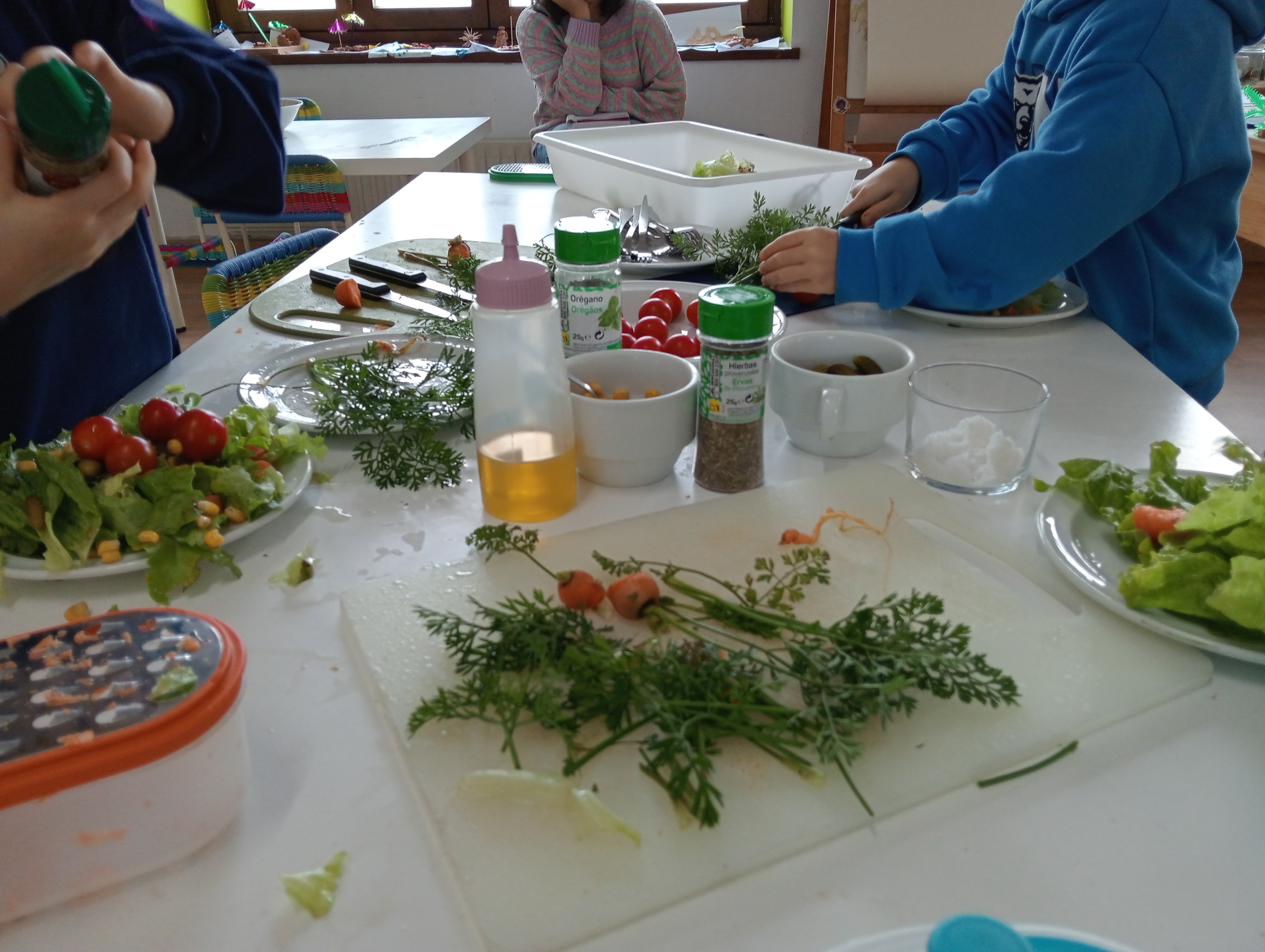 Primer pla d'una taula on els alumnes manipulen fruites i verdures