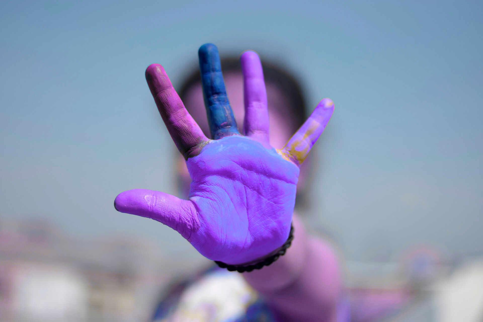 Primer plano de una mano abierta con pintura violeta