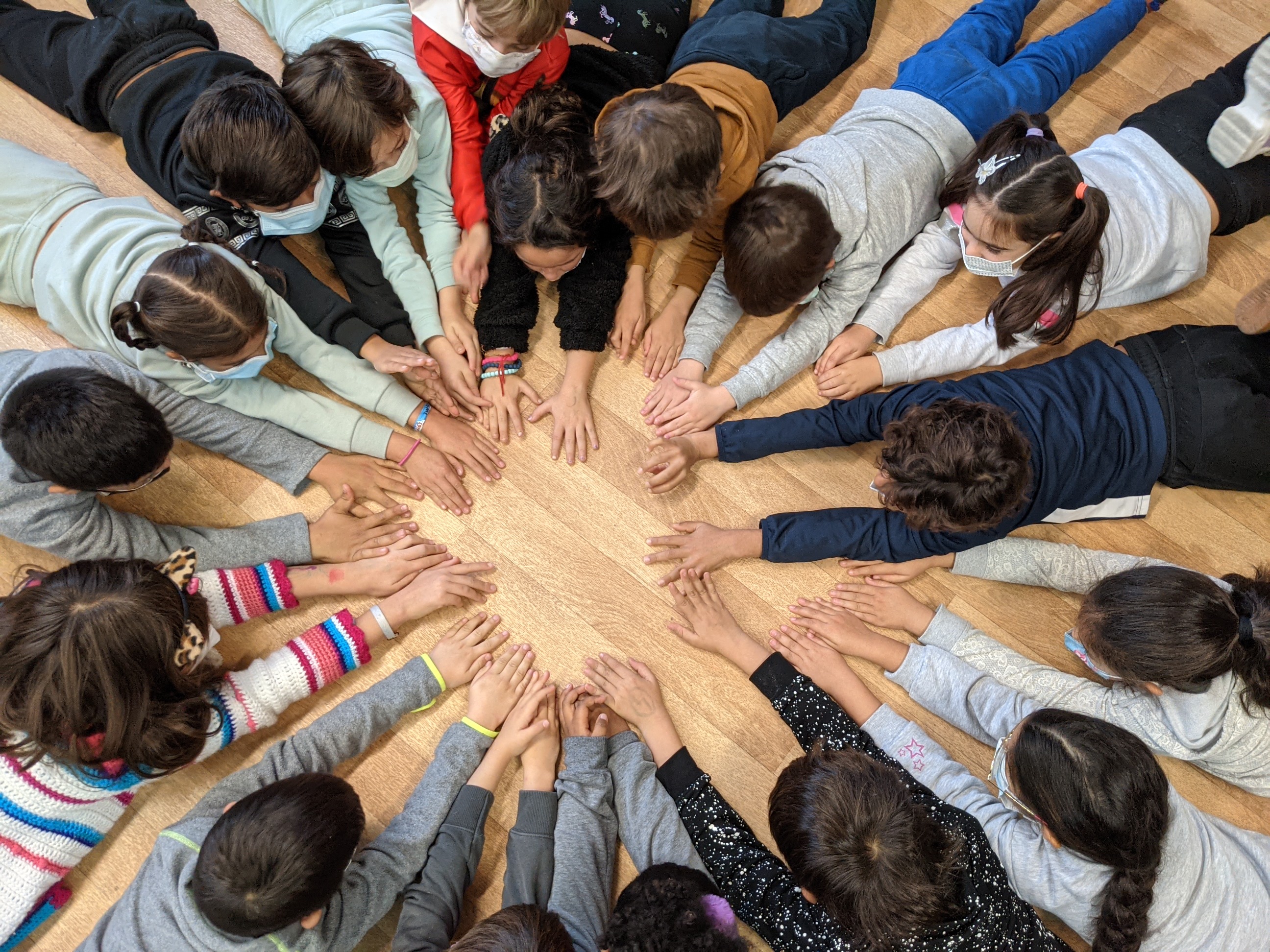 Los alumnos sentados en círculo, con las manos en el centro