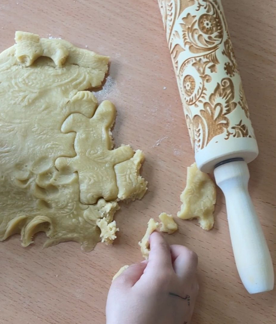 Primer plano de la elaboración de una galleta donde el alumno utiliza un rodillo que imprime figuras