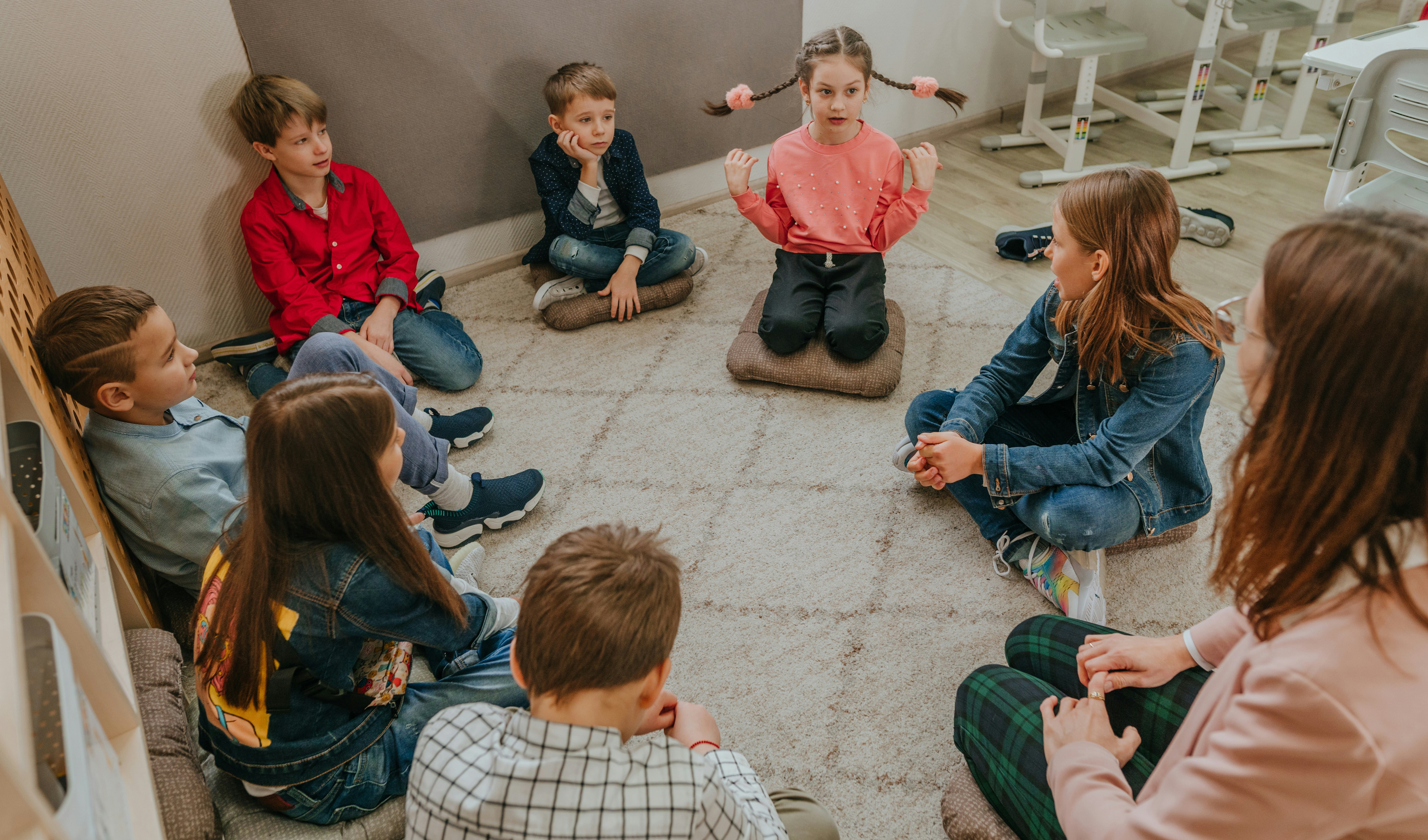 Diferents alumnes asseguts al terra formant un cercle i conversant