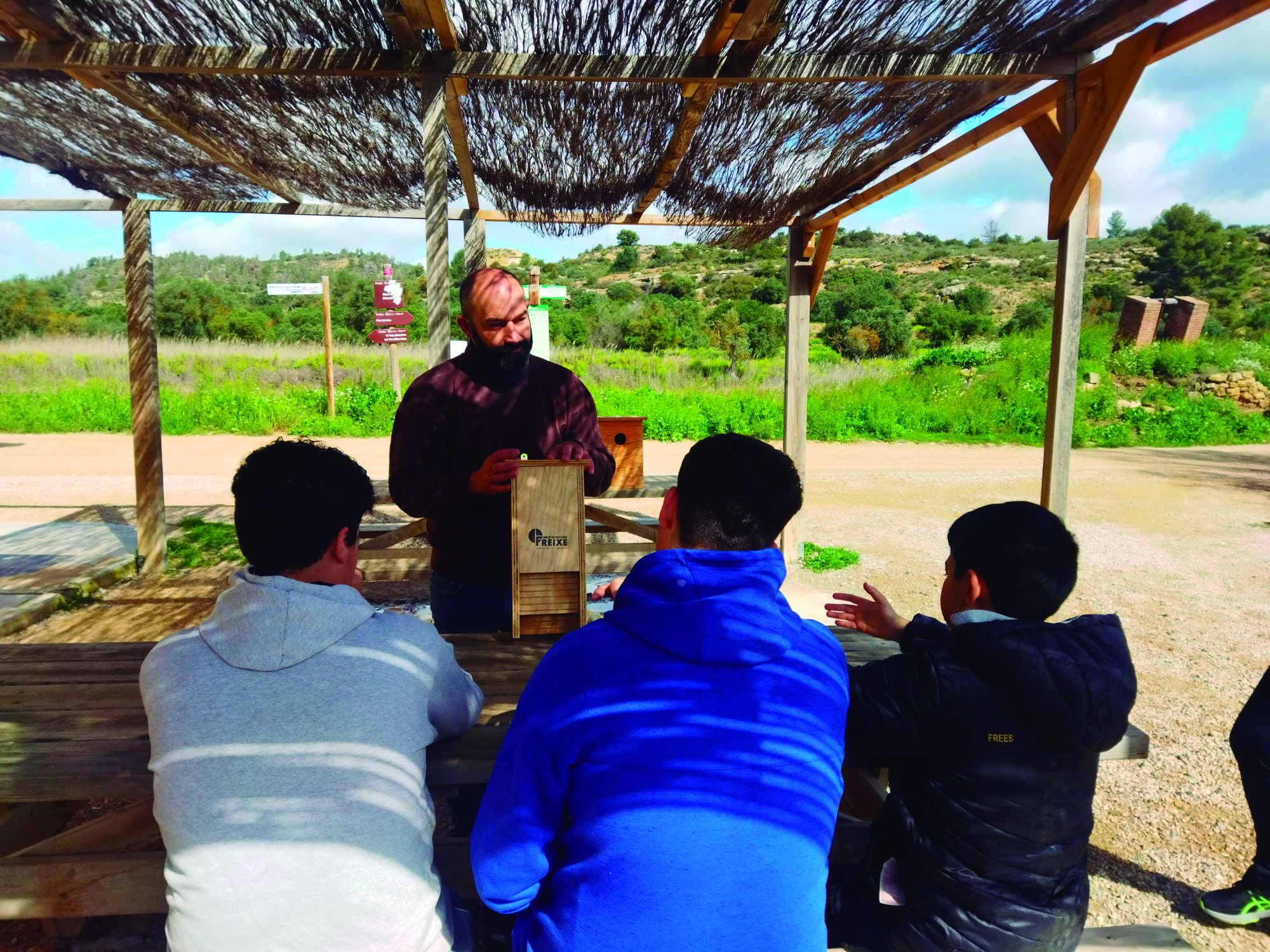 Tres alumnos escuchando la exposición de un experto